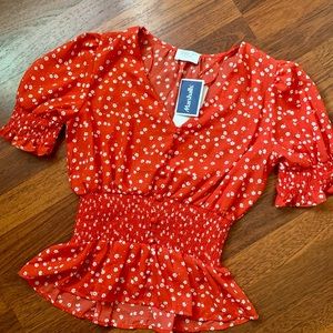 Red flowered blouse with a scrunched waist to give a beautiful hourglass figure